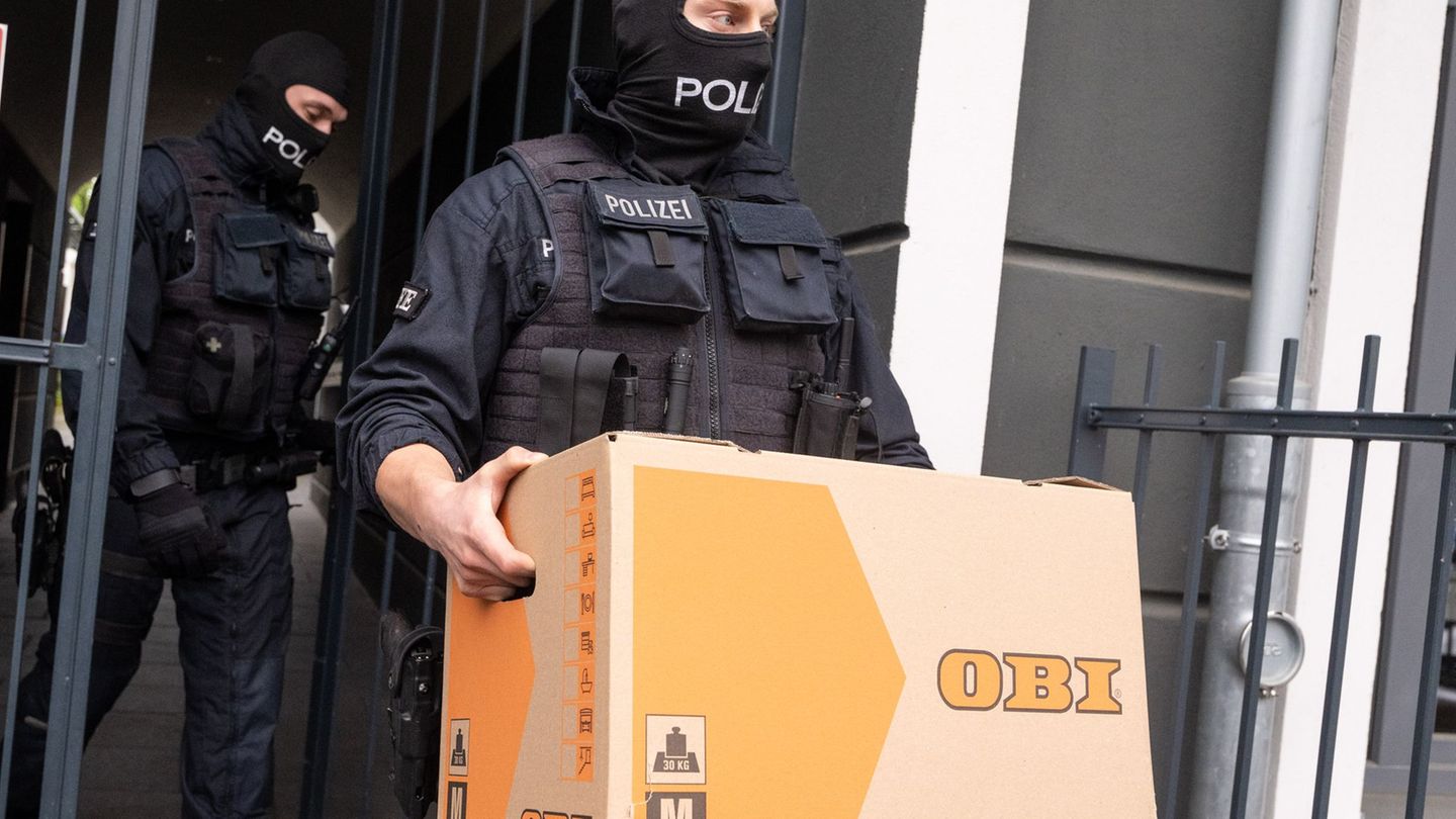 Ein Polizist trägt im Rahmen der Razzia gegen die Schleuser-Bande einen Karton aus einem Gebäude (Archivfoto) Foto: Benjamin Wes