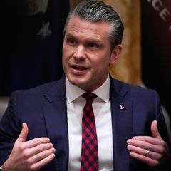 US-Verteidigungsminister Pete Hegseth sitzt an einem Tisch und weist mit beiden Händen auf sich