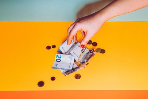 Eine Hand greift nach Bargeld