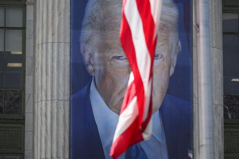 Foto von einem Bild von Donald Trump, eine US-amerikanische Fahne verdeckt das Gesicht halb