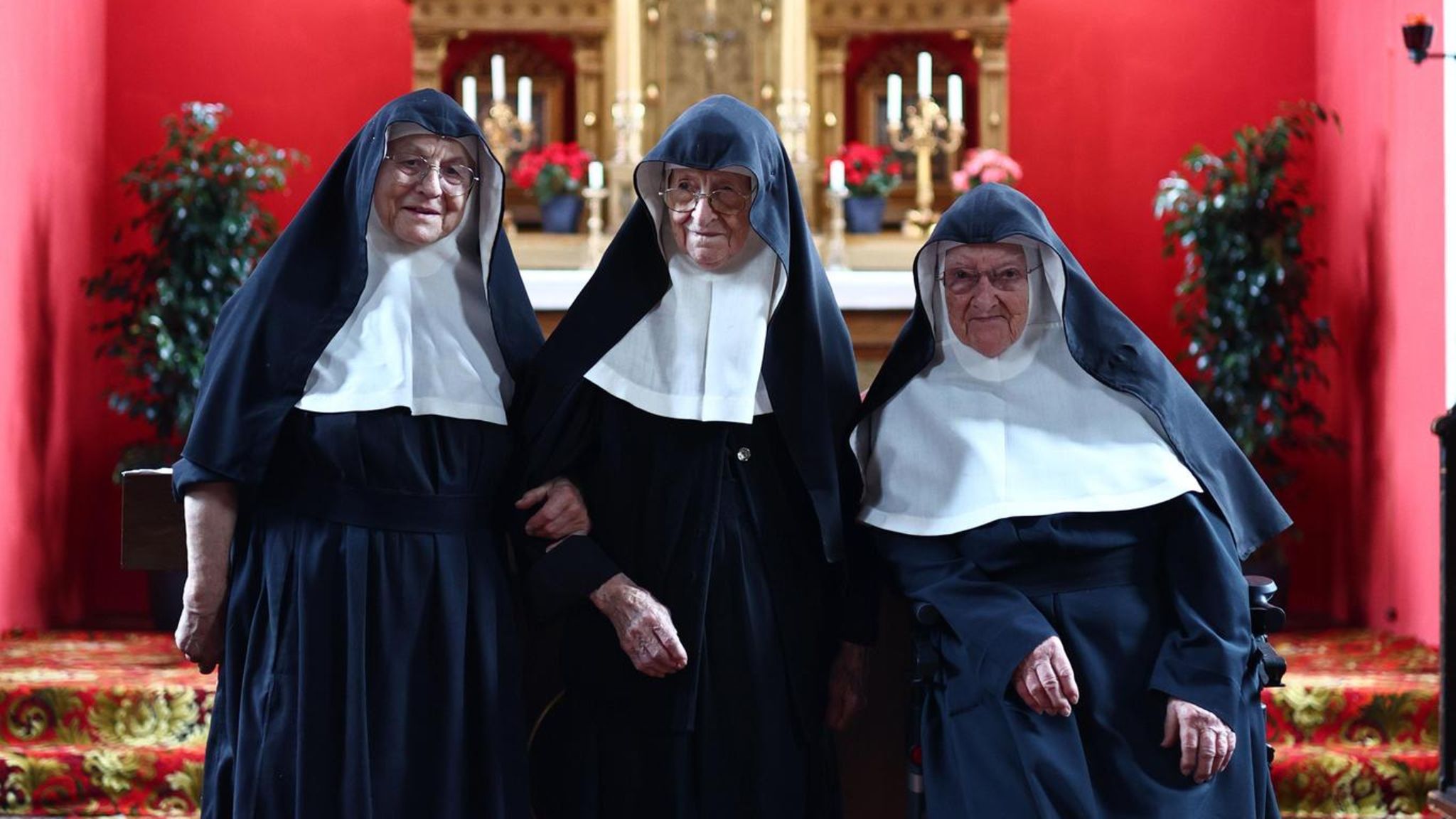 Drei Nonnen vor einem Altar