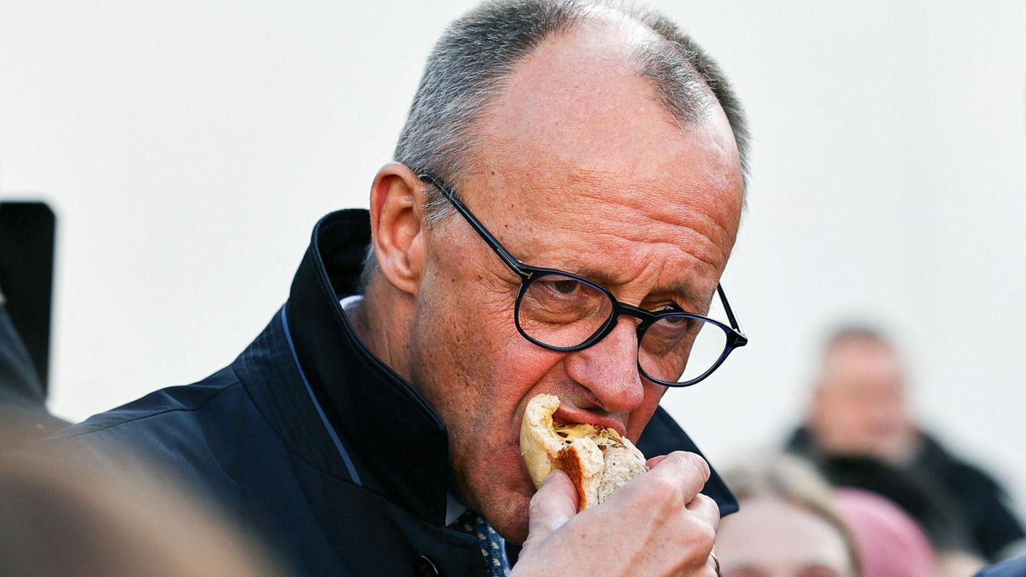 Friedrich Merz beißt in eine Bratwurst