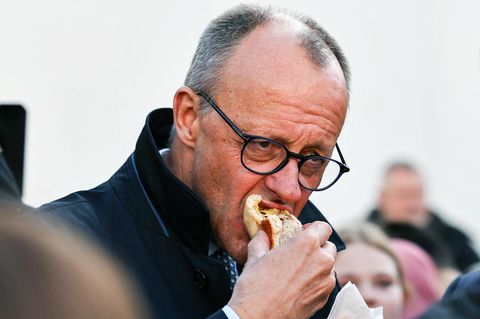 Friedrich Merz beißt in eine Bratwurst