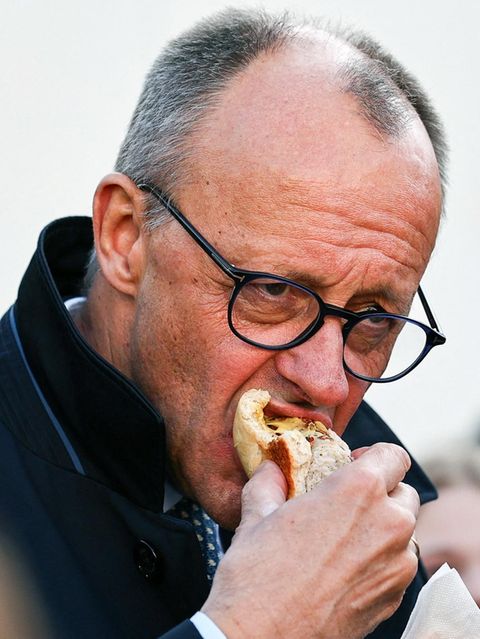 Friedrich Merz beißt in eine Bratwurst
