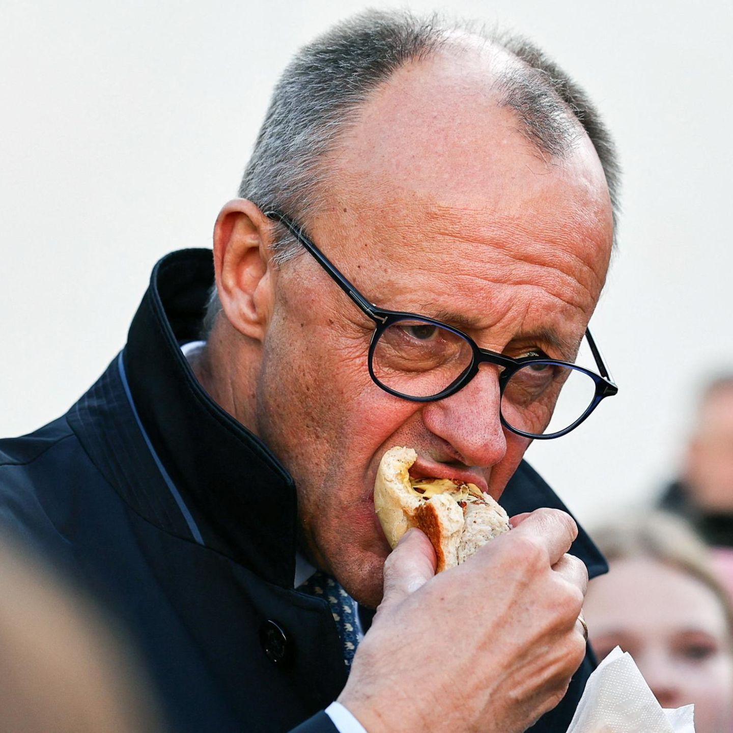 Friedrich Merz beißt in eine Bratwurst