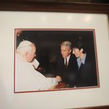 Aufnahme eines eingerahmten Fotos, das offenbar Jeffrey Epstein und seine Komplizin Ghislaine Maxwell bei einem Treffen mit dem Papst zeigt. Wann die Aufnahme entstanden ist, ist nicht bekannt