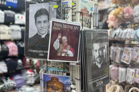 Rund um den Petersdom werden Kalender von Papst Leo XIV. sowie echten und falschen Priestern verkauft. Foto: Christoph Sator/dpa
