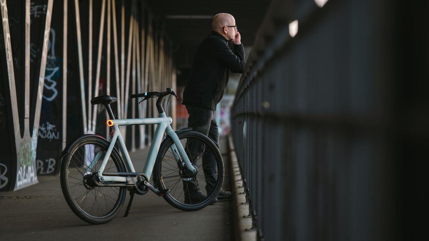 Ein Vanmoof S6 steht mit einem Mann auf einer Brücke