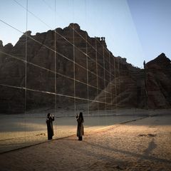 Eine Frau steht vor einem verspiegelten Gebäude