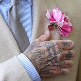Die tätowierte Hand von David Beckham richtet eine Blume am Revers