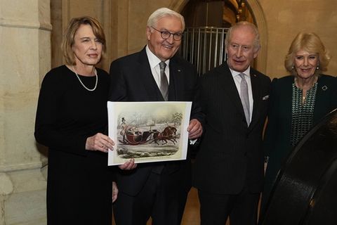 Elke Büdenbender und Frank-Walter Steinmeier zeigen ein Bild des Schlittens neben König Charles und Königin Camilla (v.l.n.r.)