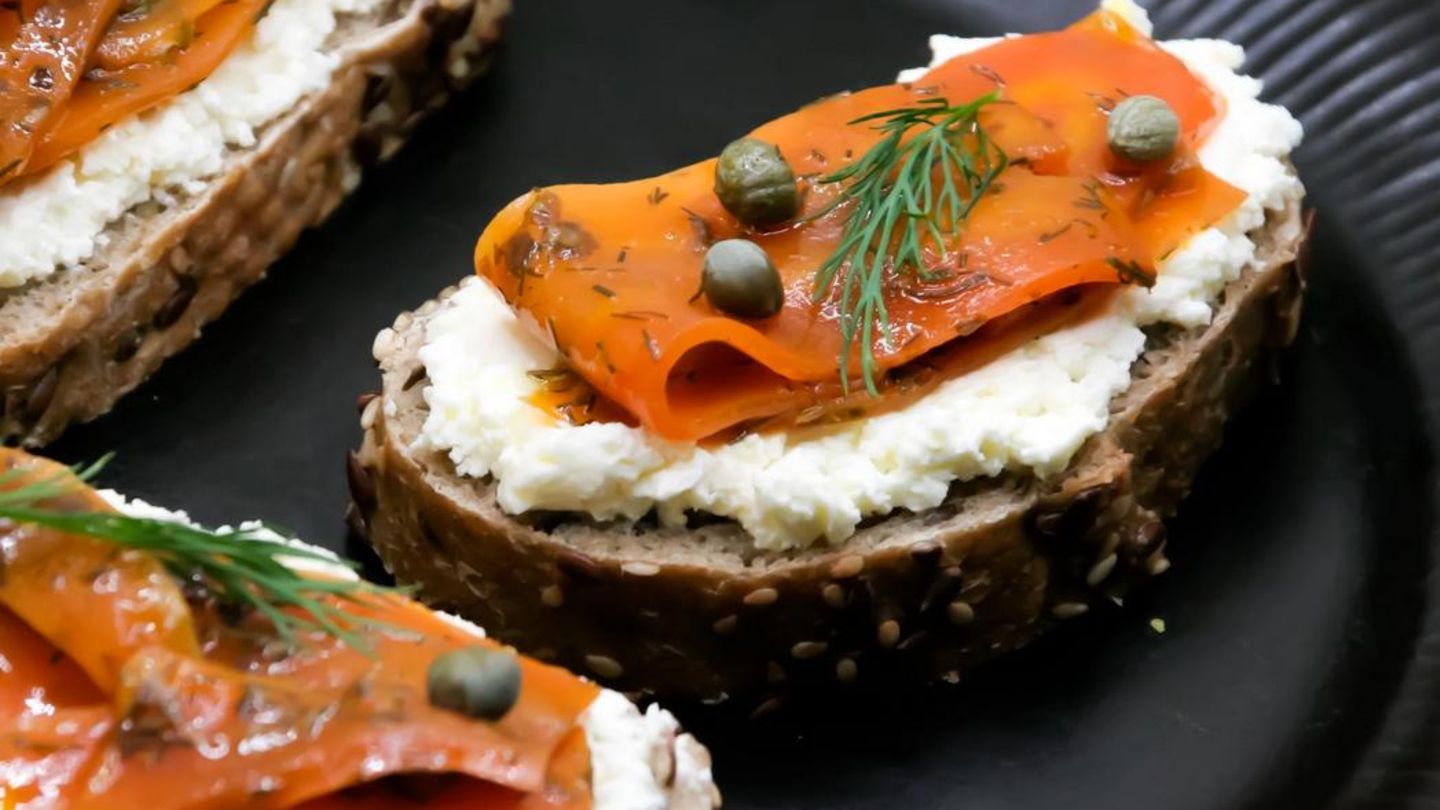 Ein Brot bestrichen mit Frischkäse mit einem aus Möhren nachgemachten Lachs belegt