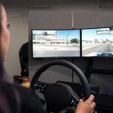 Eine Frau steuert aus der Ferne ein echtes Auto auf der Straße