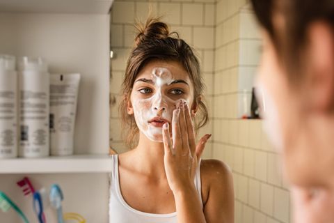 Thema Hautpflege: Mädchen cremt sich ein.
