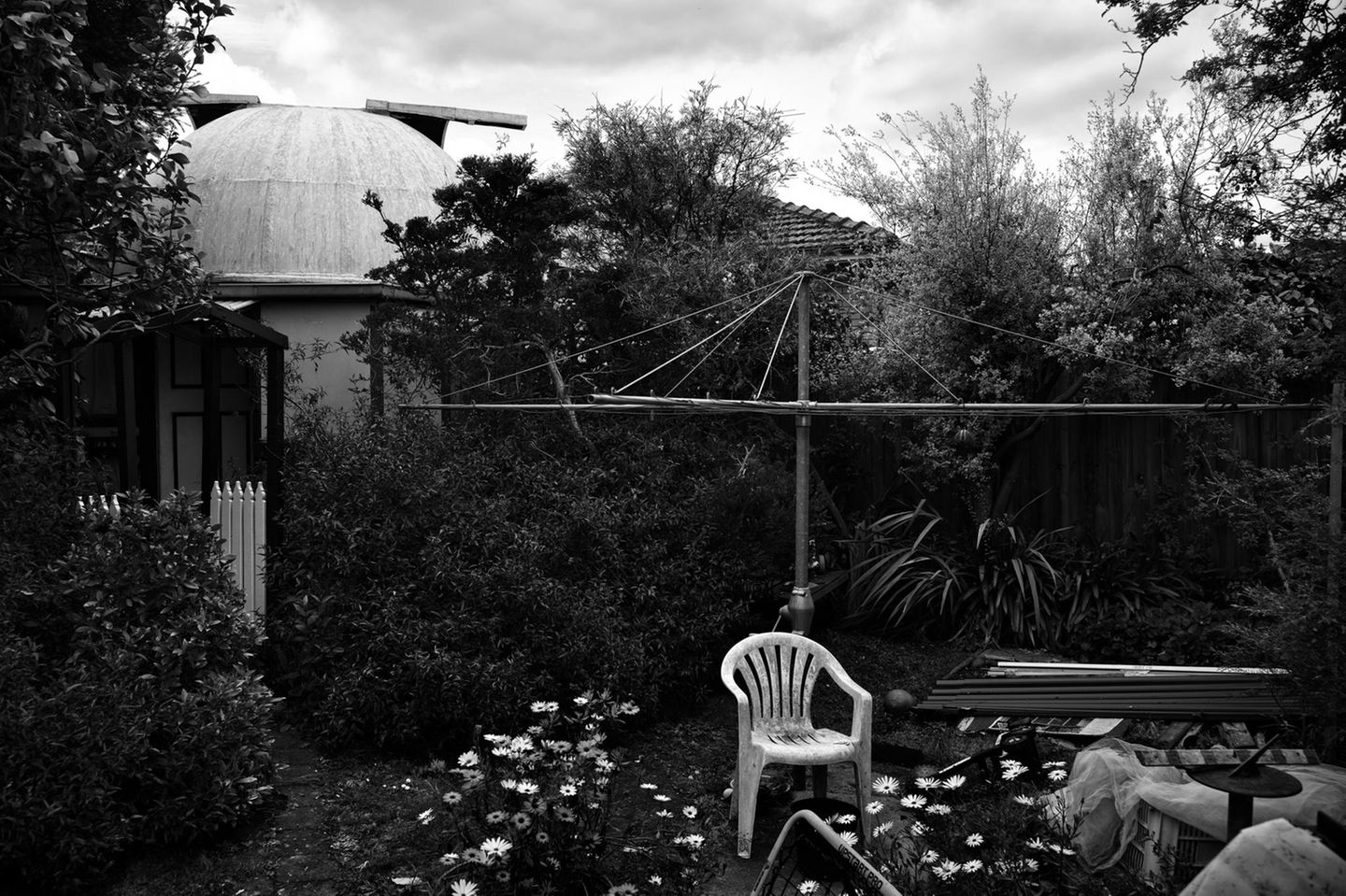 Ein Heimobservatorium in einem Garten in Australien. Im Vordergrund steht ein weißer Gartenstuhl
