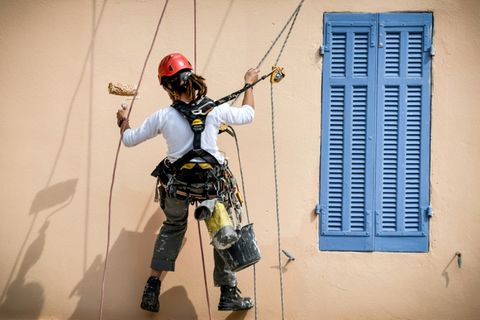 Anstreicherin an einem Haus