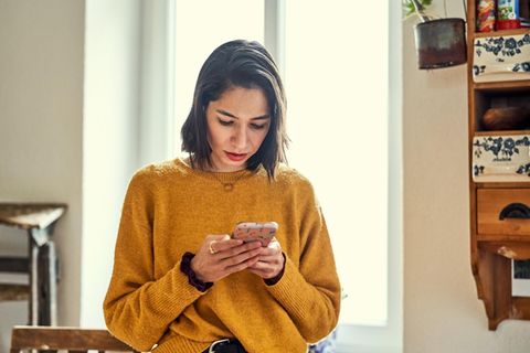 Eine Frau nutzt ihr Smartphone. Chattet sie bei Whatsapp?