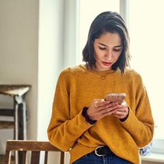 Eine Frau nutzt ihr Smartphone. Chattet sie bei Whatsapp?