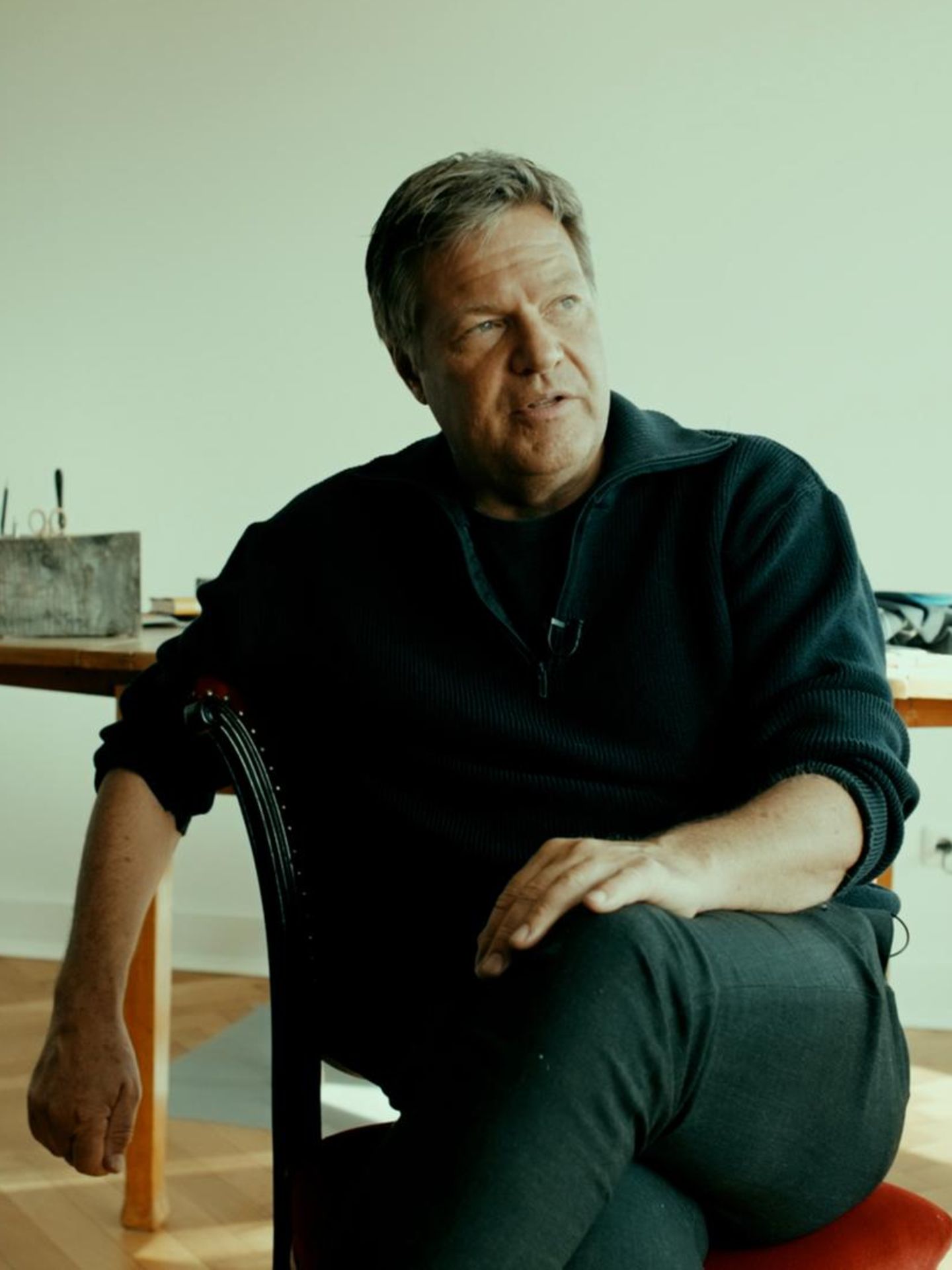 Robert Habeck sitzt auf einem Stuhl und spricht