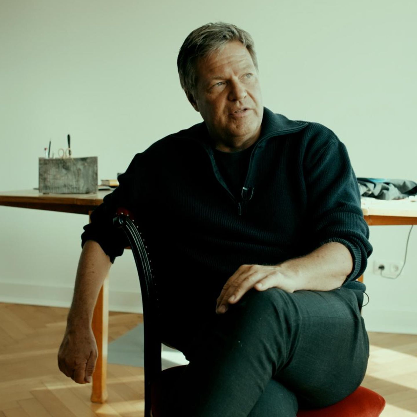 Robert Habeck sitzt auf einem Stuhl und spricht