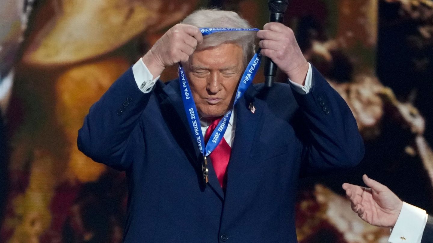US-Präsident Trump hängt sich die FIFA-Medaille selber um. Foto: Chris Carlson/AP/dpa