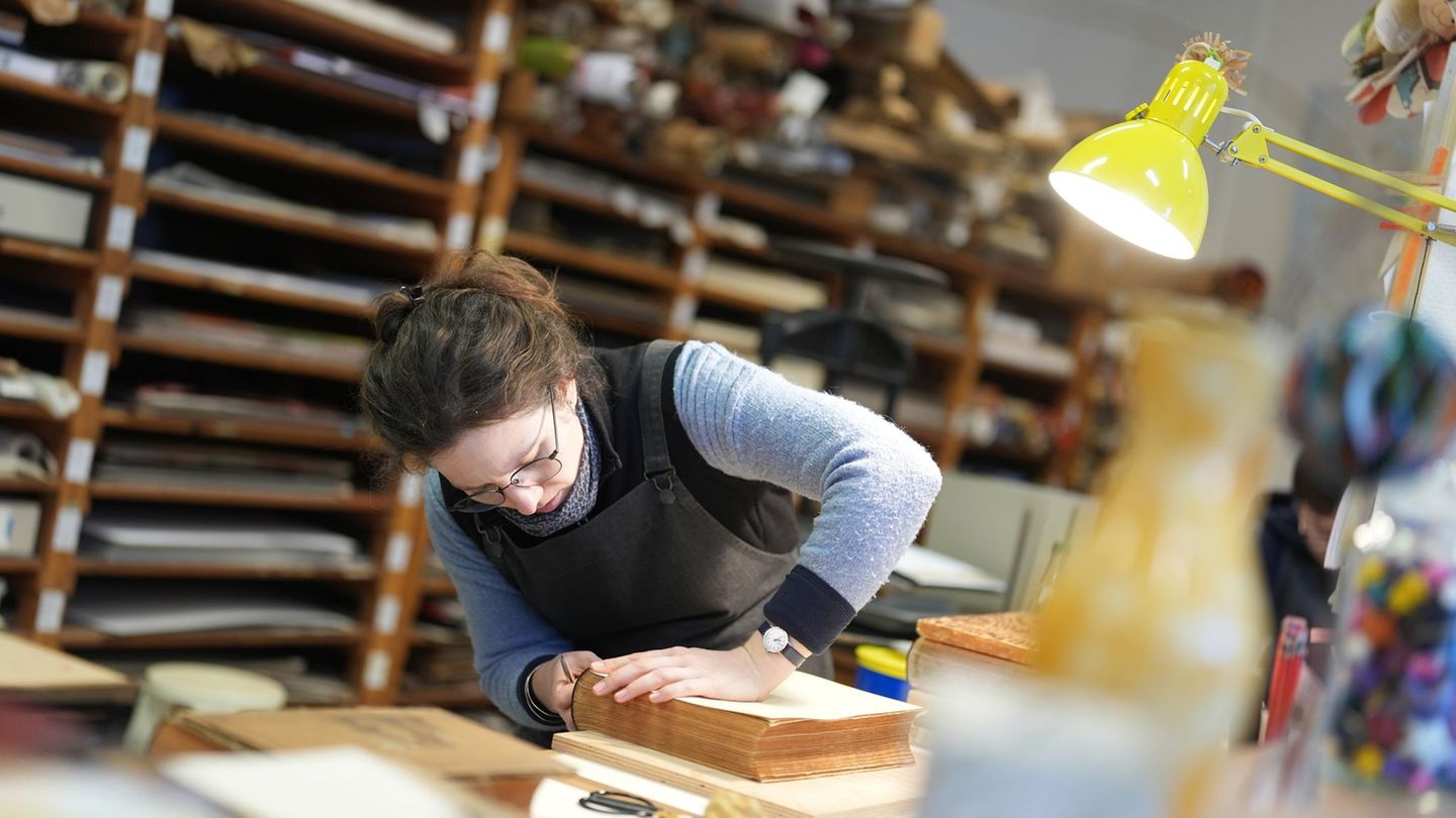 Buchbinderin Moiken Petong restauriert in der Werkstatt der Buchbinderei Fritz Castagne ein altes Buch. Foto: Marcus Brandt/dpa