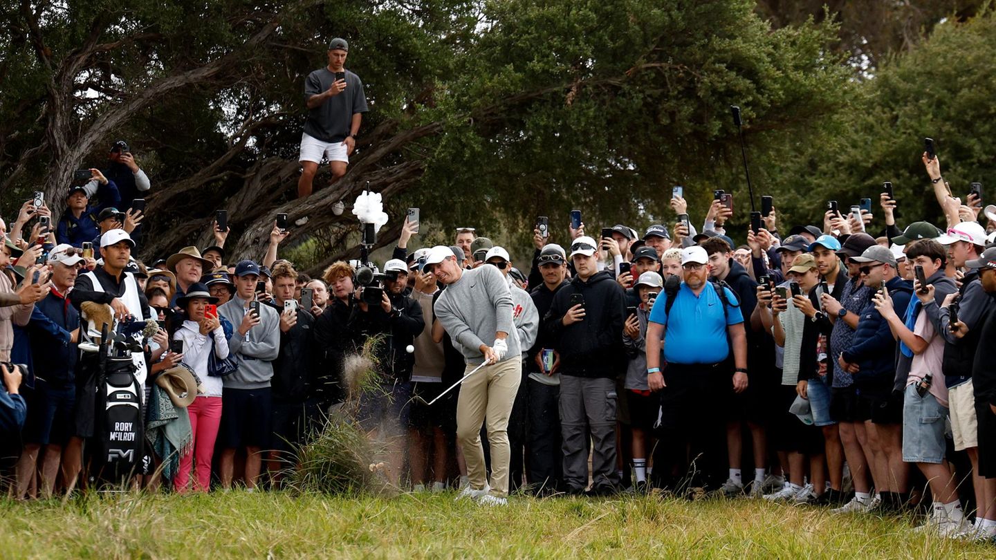 Ein Golfspieler schlägt gerade ab, eine menschentraube steht hinter ihm und schaut zu