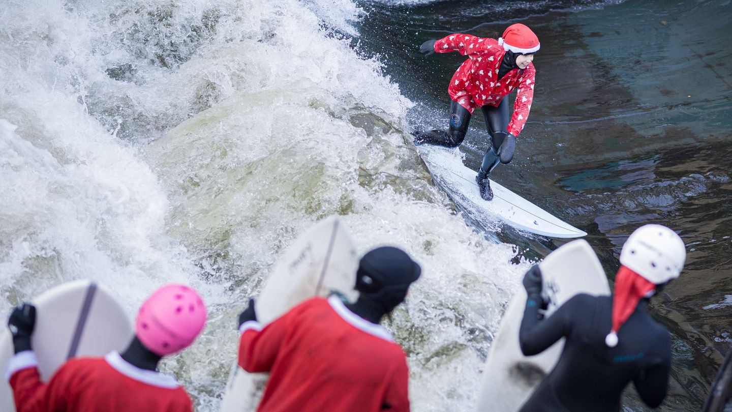 Beim "Santa Surf" stürzen sich verkleidete Surfer in die eiskalte Leinewelle in Hannover. Foto: Moritz Frankenberg/dpa