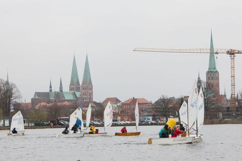 Segler in kleinen Jollen nehmen an der "Eisarschregatta" des Lübecker Yacht-Clubs teil. Foto: Georg Wendt/dpa