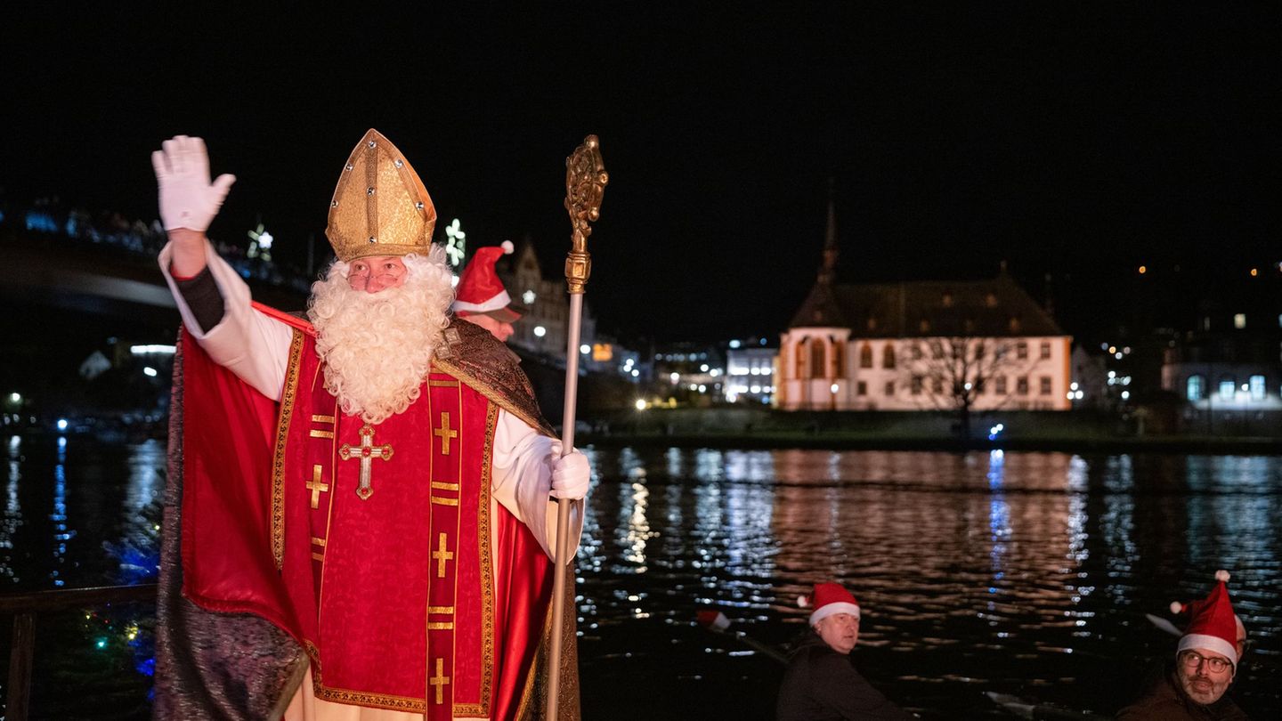 Von zahlreichen Fackelschwimmern begleitet ist der Nikolaus in Bernkastel-Kues in einem Ruderboot über die Mosel gekommen. Foto: