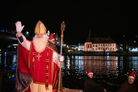 Von zahlreichen Fackelschwimmern begleitet ist der Nikolaus in Bernkastel-Kues in einem Ruderboot über die Mosel gekommen. Foto: