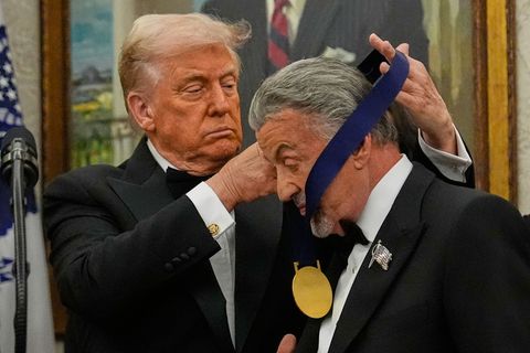 US-Präsident Donald Trump hängt der Actionfilm-Ikone Sylvester Stallone eine Medaille um. Foto: Julia Demaree Nikhinson/AP/dpa