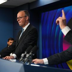 Friedrich Merz und Benjamin Netanjahu stehen nebeneinander hinter Rednerpulten. Netanjahu erhebt den linken Zeigefinger