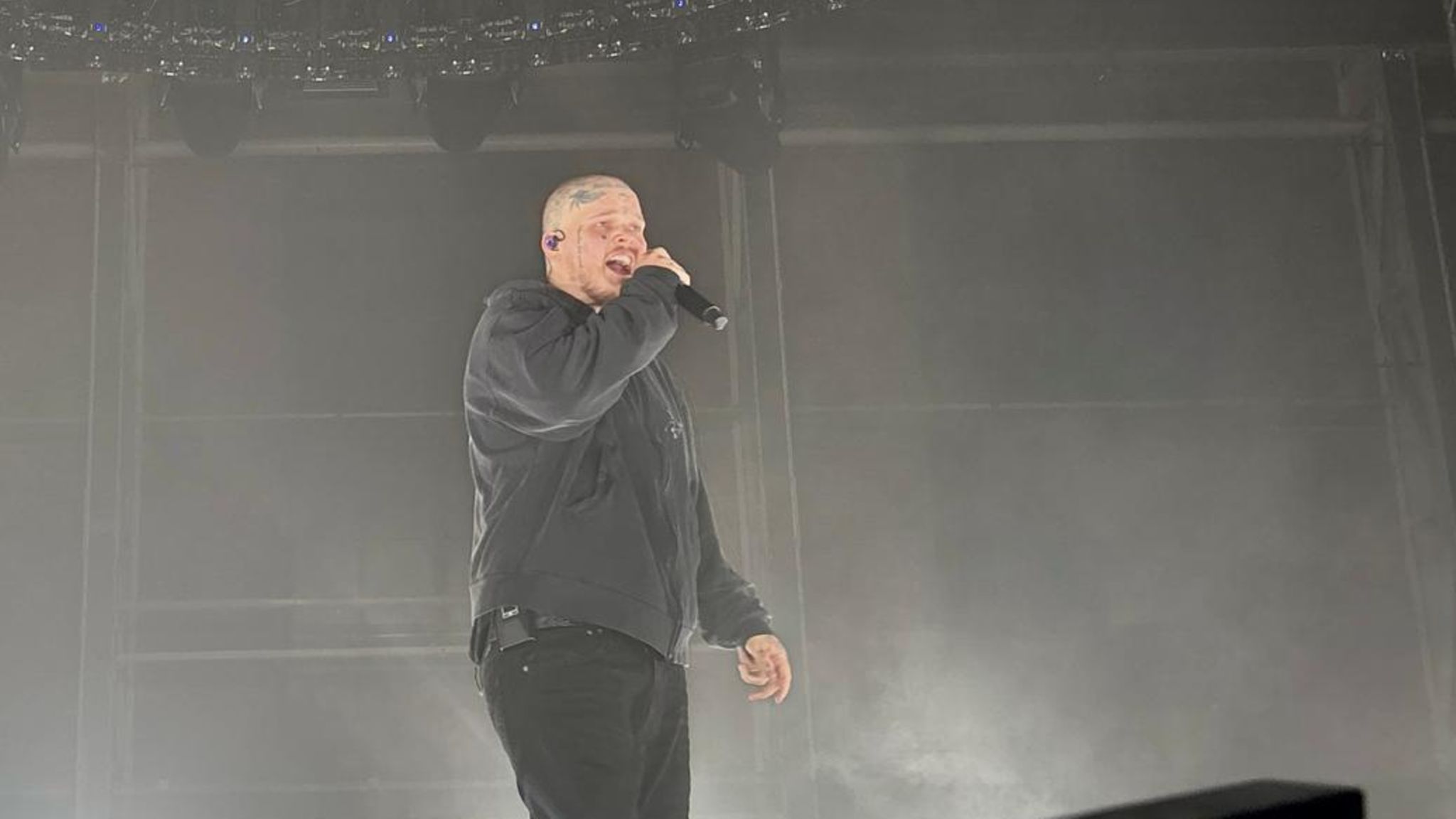 Sierra Kidd am Samstagabend in Papenburg. Er trägt Glatze und Tattoos und singt in ein Mikro