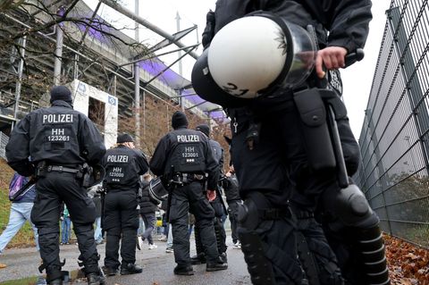 Einsatzkräfte der Polizei stehen vor dem Derby vor dem Volksparkstadion. Foto: Christian Charisius/dpa