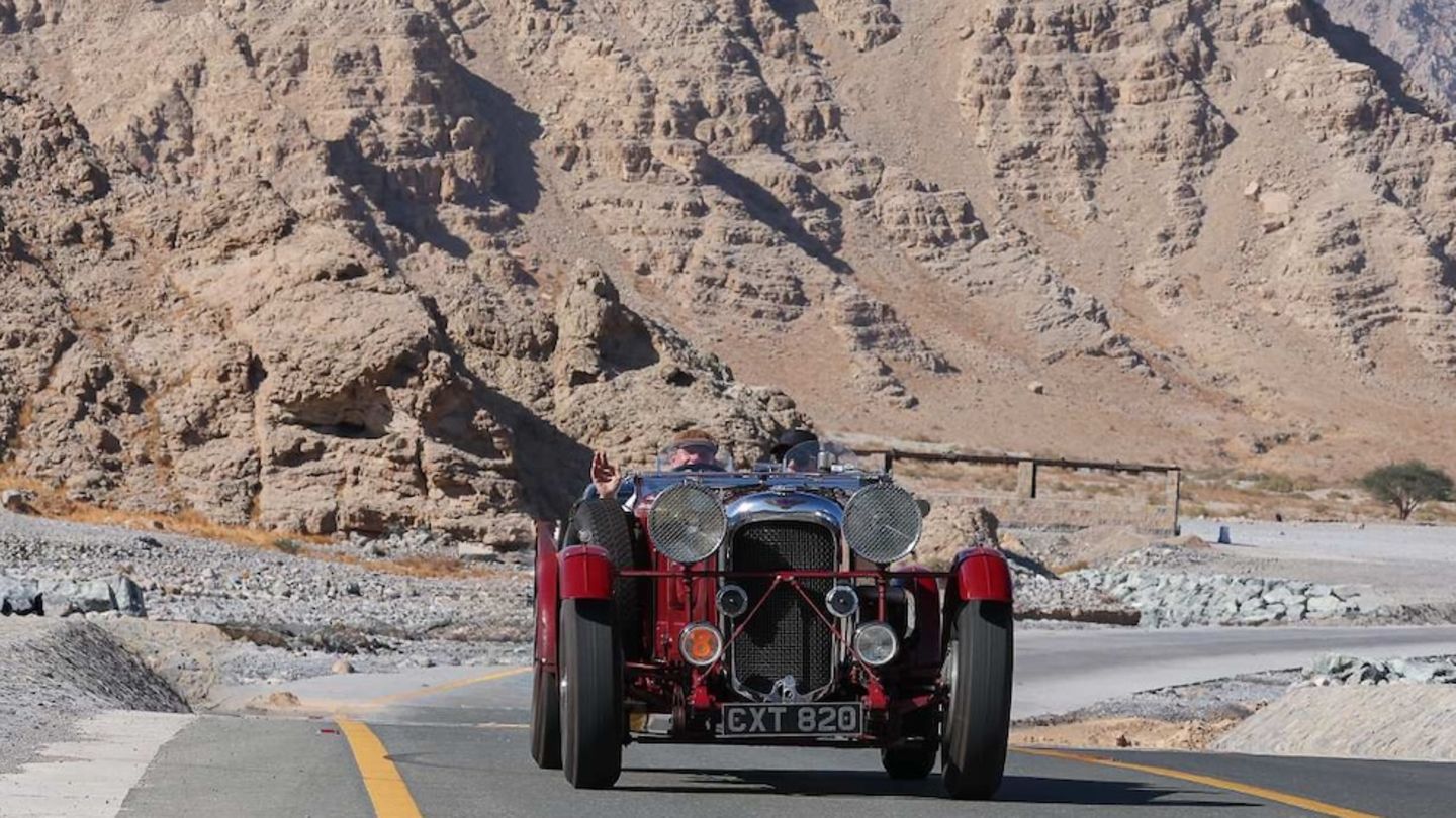 Oldtimer auf der Straße zwischen den Bergen