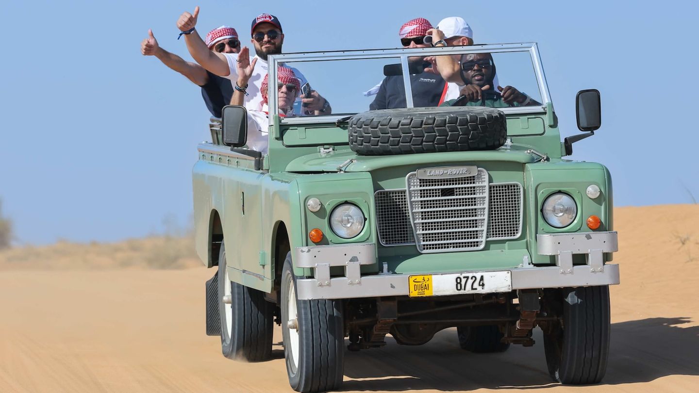 Menschen auf einem Land Rover in der Wüste