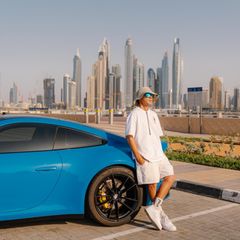 Ein Mann posed vor seinem Auto