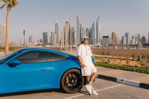 Ein Mann posed vor seinem Auto