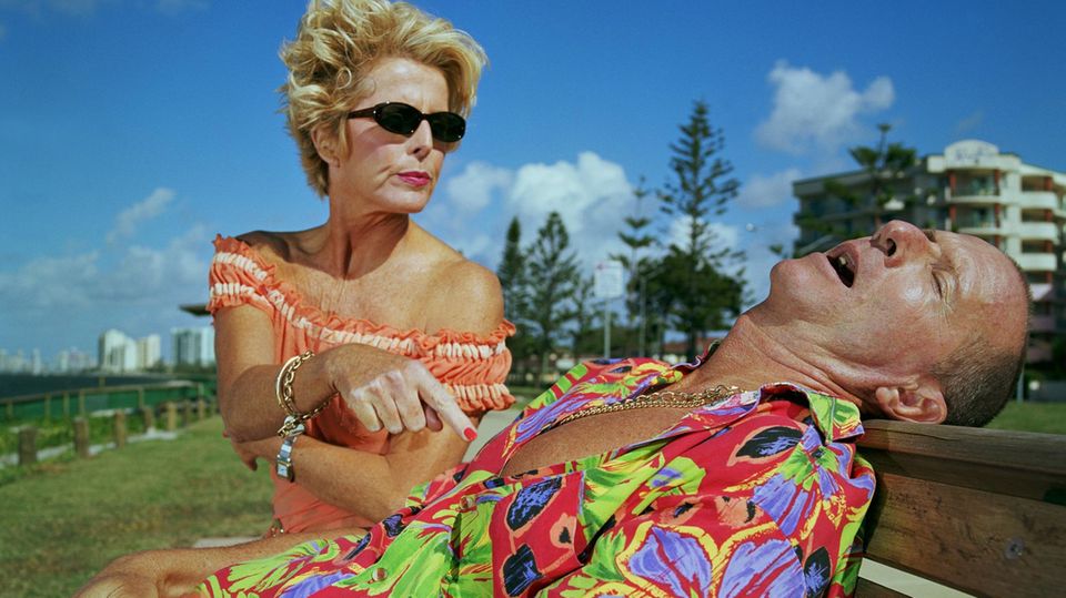 Eine Frau tippt ihren schlafenden Mann an