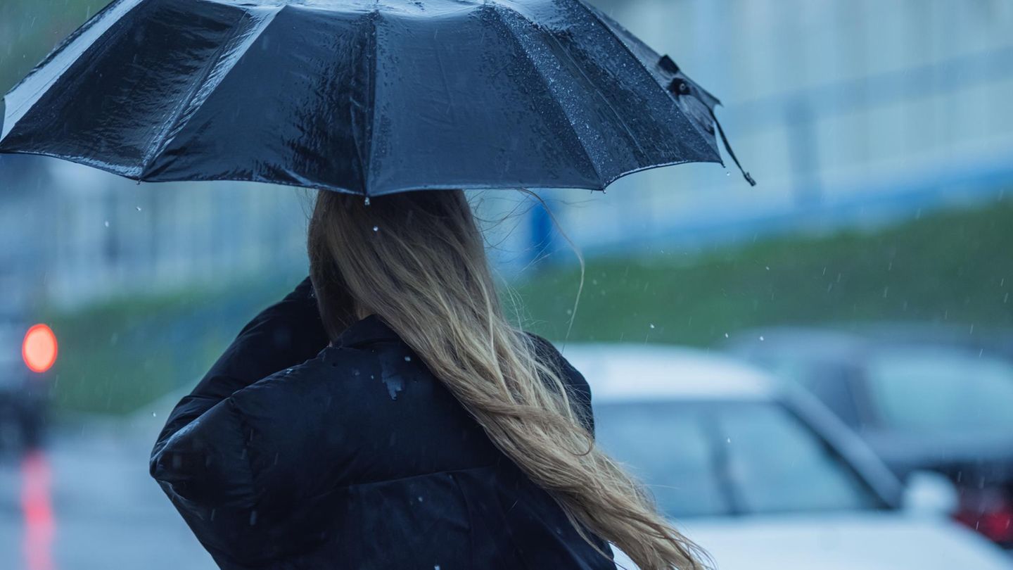 Deal News: Eine Frau steht unter einem Regenschirm