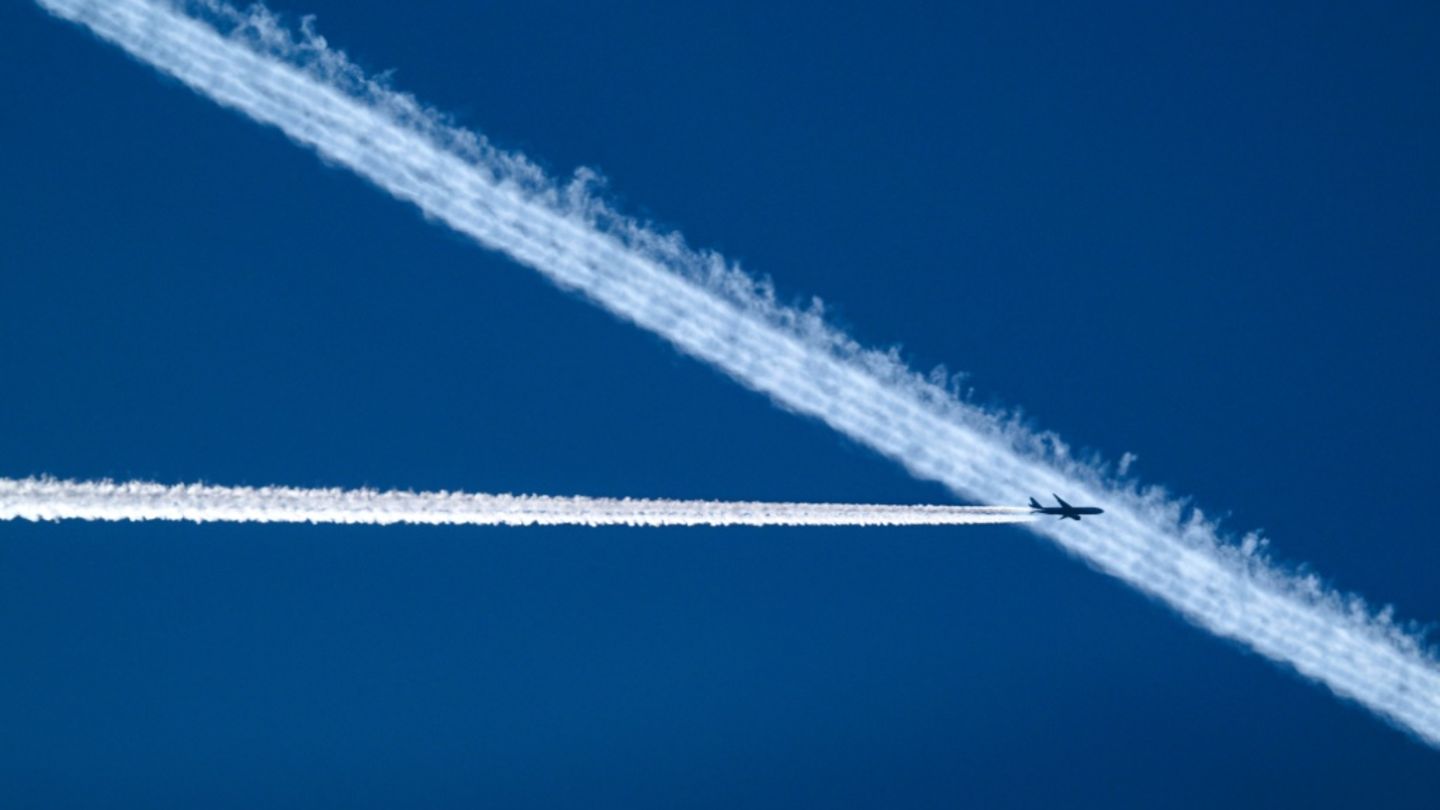 Flugzeug hinterlässt Kondensstreifen am Himmel