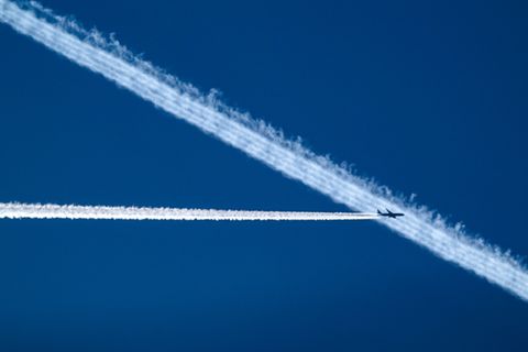 Flugzeug hinterlässt Kondensstreifen am Himmel