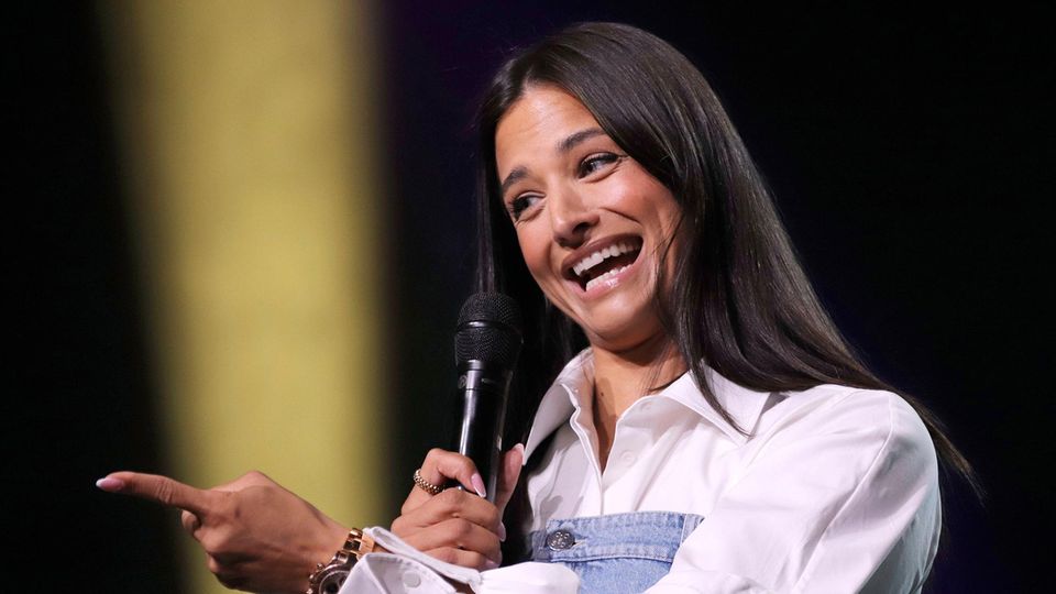 Amira Aly mit einem Mikrofon in der Hand