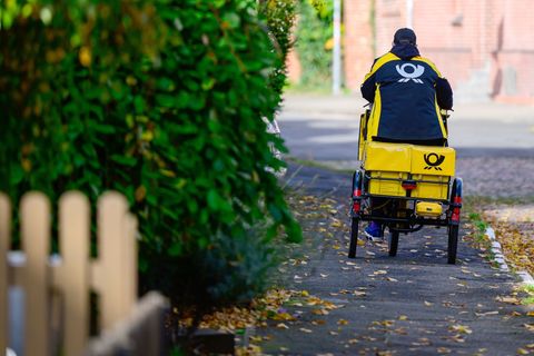 Ein Briefträger bei der Arbeit. Foto: Philipp Schulze/dpa