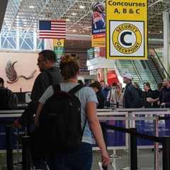 Reisende warten in einer Schlange an einer Sicherheitskontrolle Flughafen Baltimore in den USA