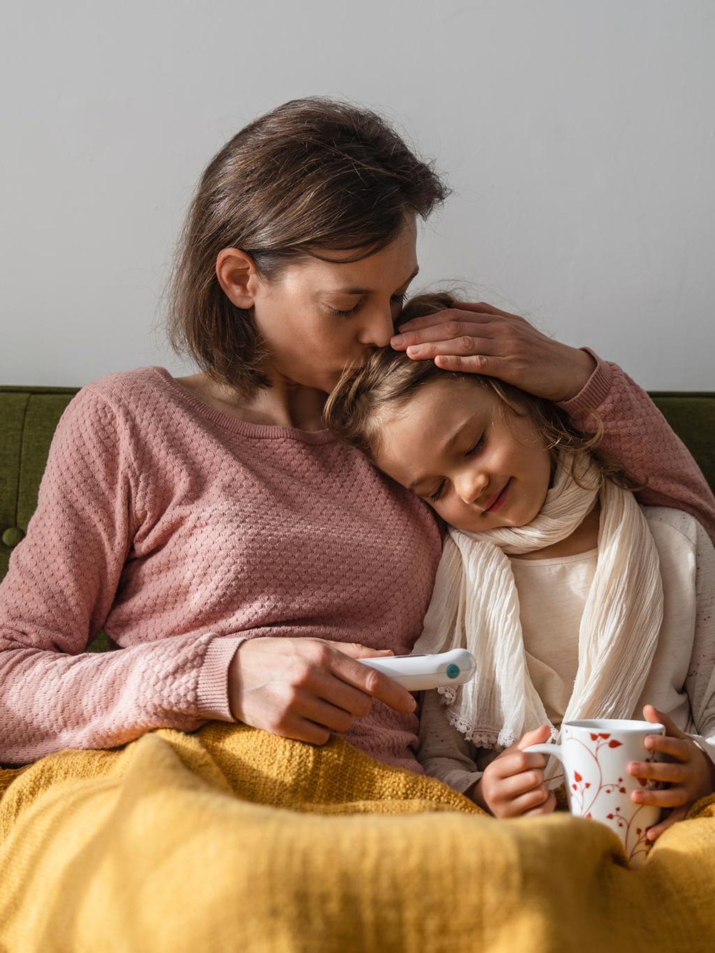 Kinderkrankheiten: Krankes Kind und Mutter auf dem Sofa