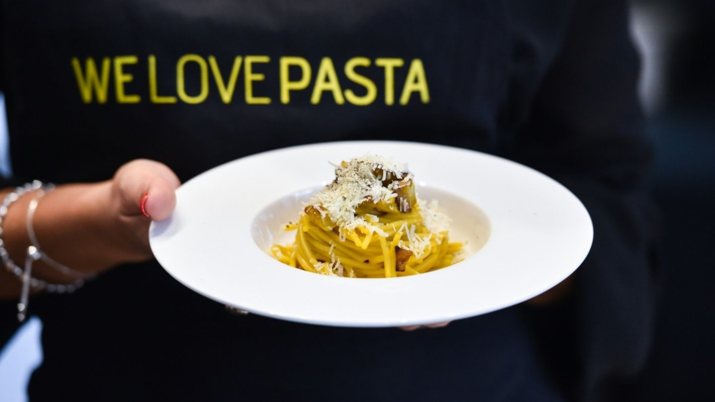 Köchin mit einem Teller Pasta