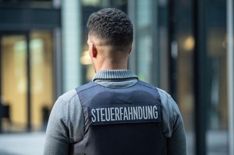 Ein Mann trägt eine Weste mit dem Schriftzug "Steuerfahnder" auf dem Rücken