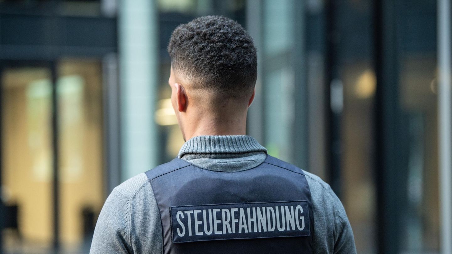 Ein Mann trägt eine Weste mit dem Schriftzug "Steuerfahnder" auf dem Rücken